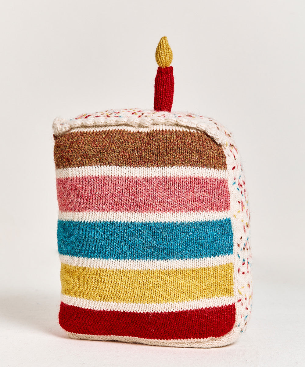 Birthday Cake Pillow featuring colorful knitted layers and topped with a red candle.