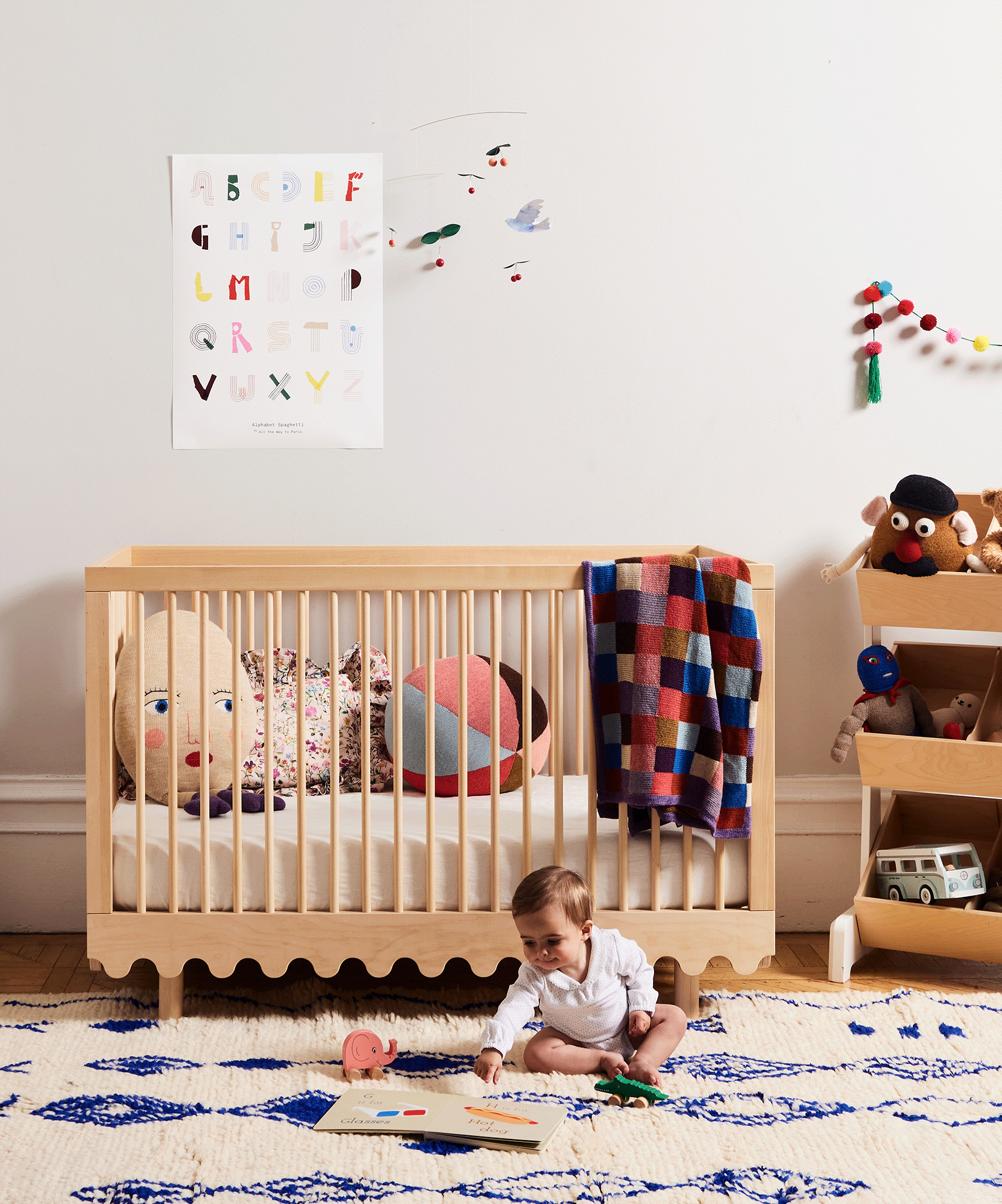 Stop-motion photo of child playing on carpeted floor in front of a Moss Crib.