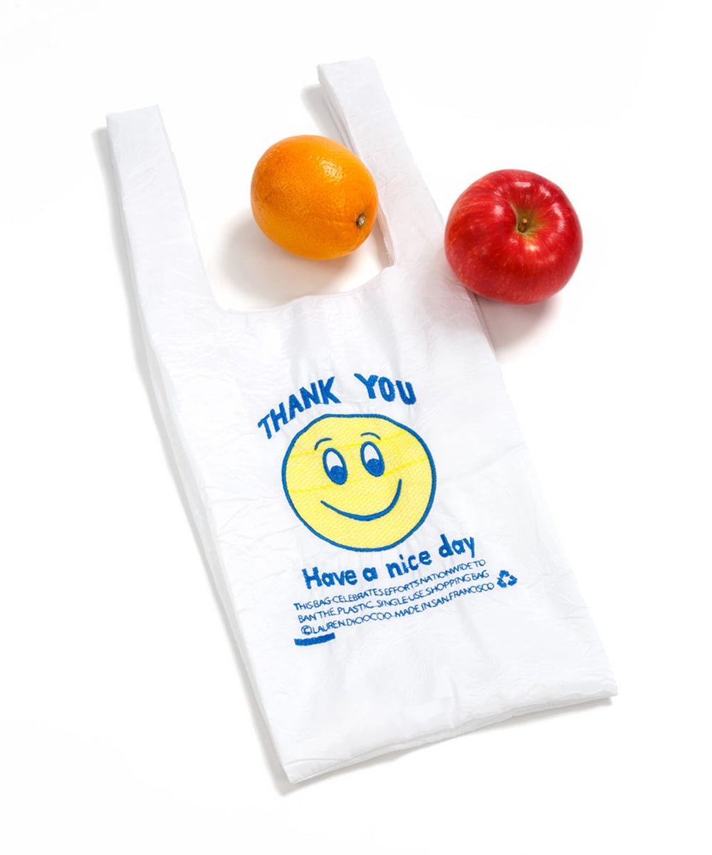 The Le Thank You Tote - Mini, featuring a smiley face, an orange, and a red apple on a white background.