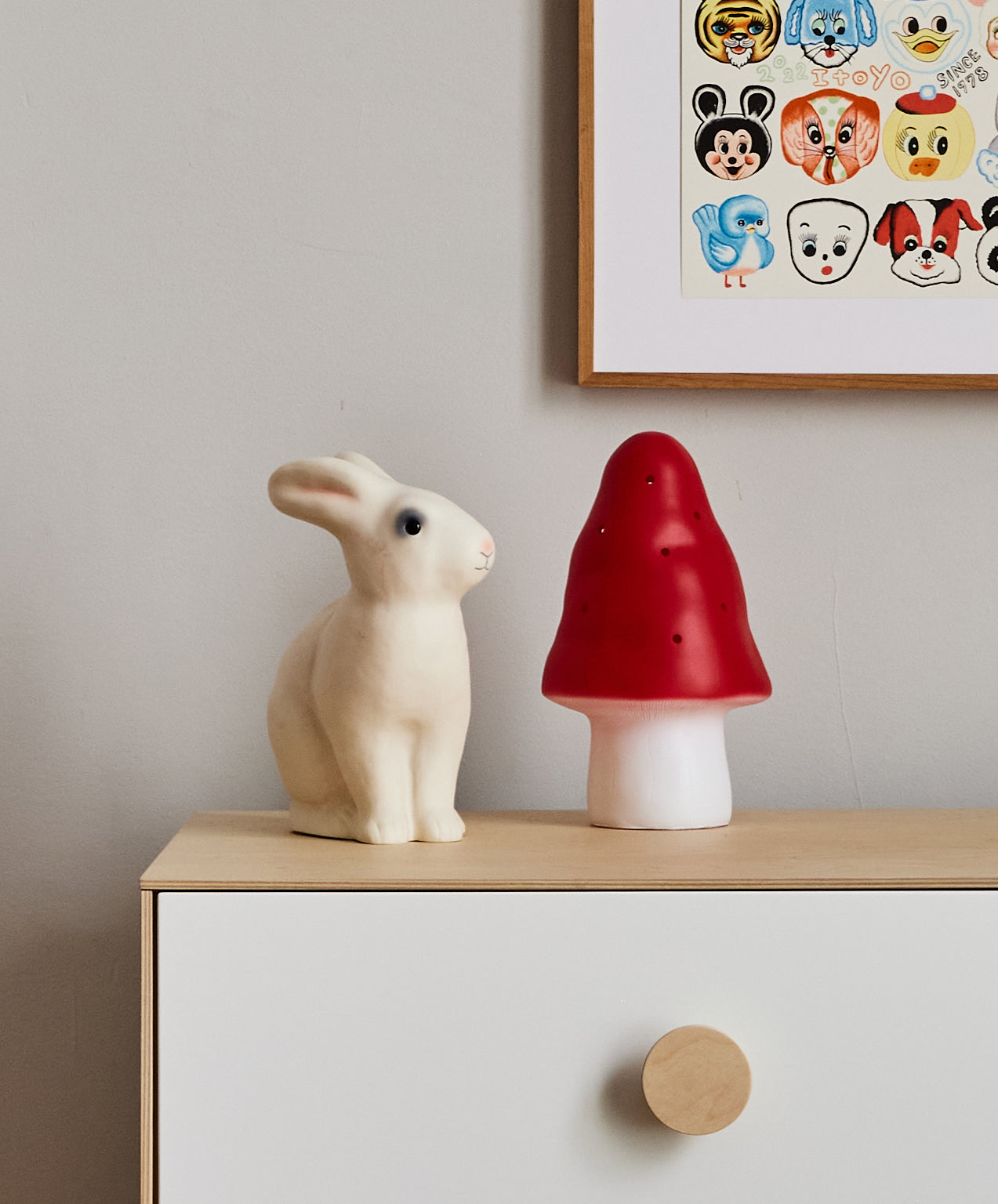 Le Bunny Lamp on a light wood cabinet, with animal art print displayed above.