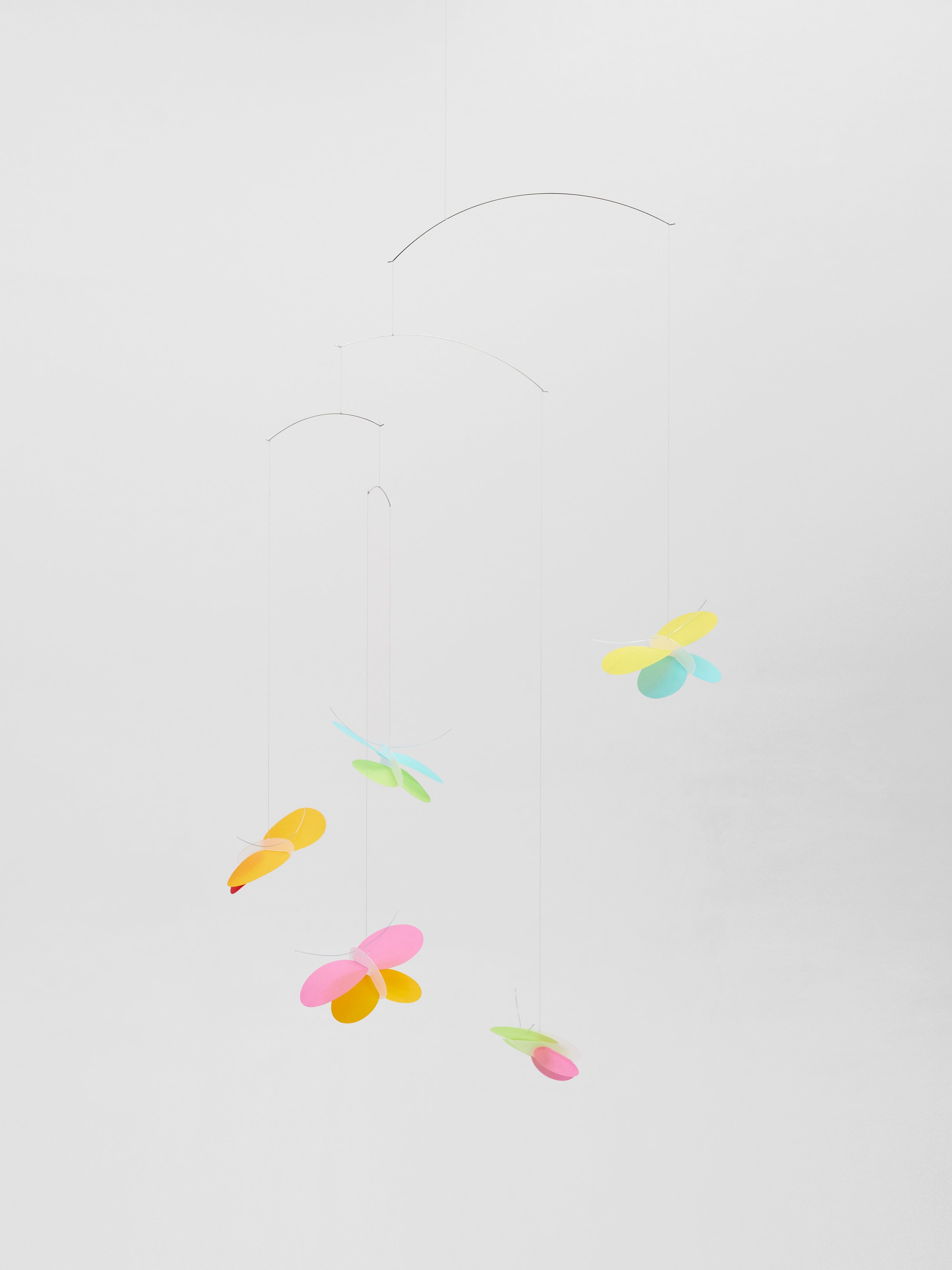 Butterflies is a minimalist mobile featuring colorful, abstract butterfly shapes hanging from thin wires against a white background.