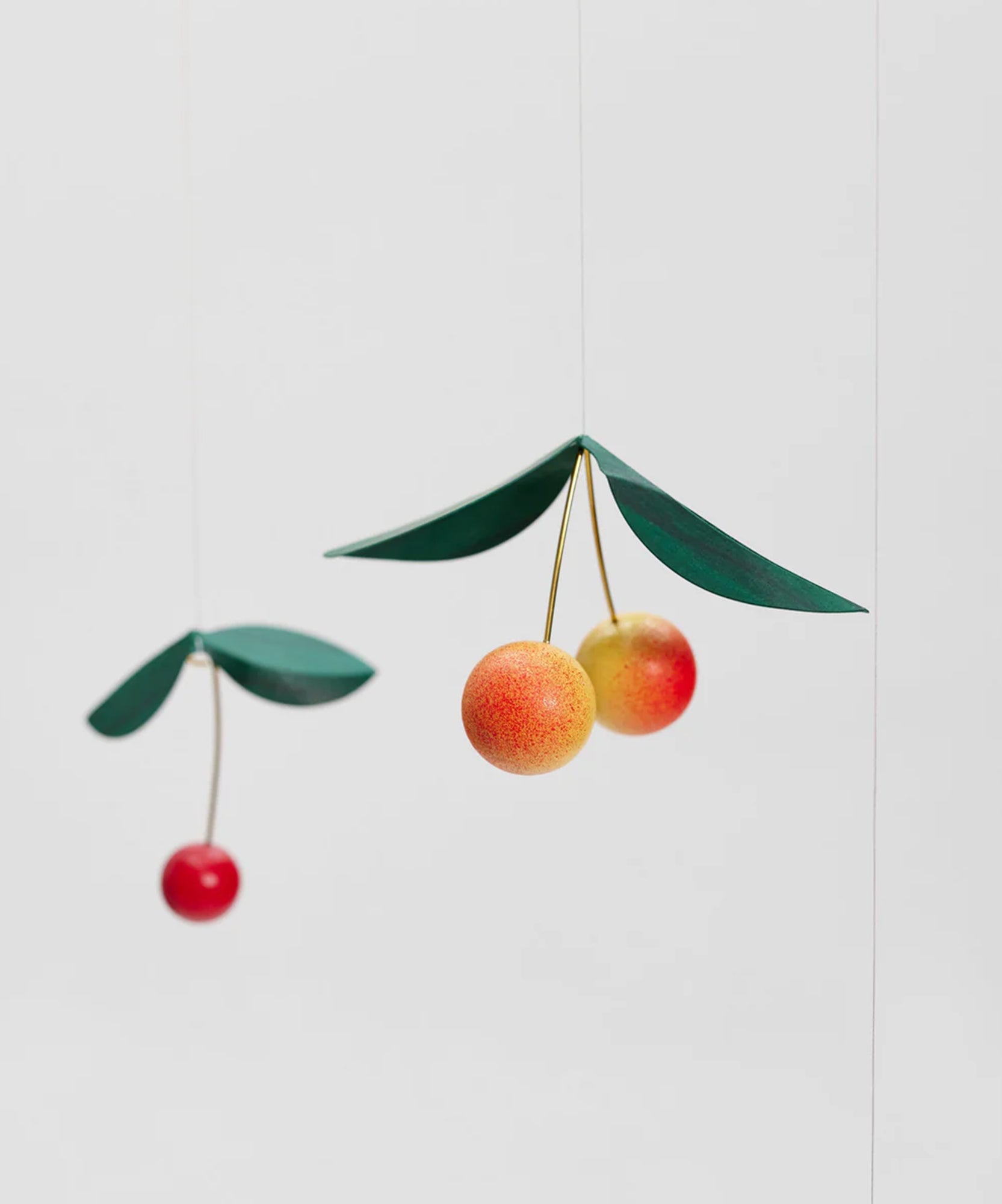 The Le Mobile - Cherry Bird features paper cherry art with green leaves on a plain white backdrop.