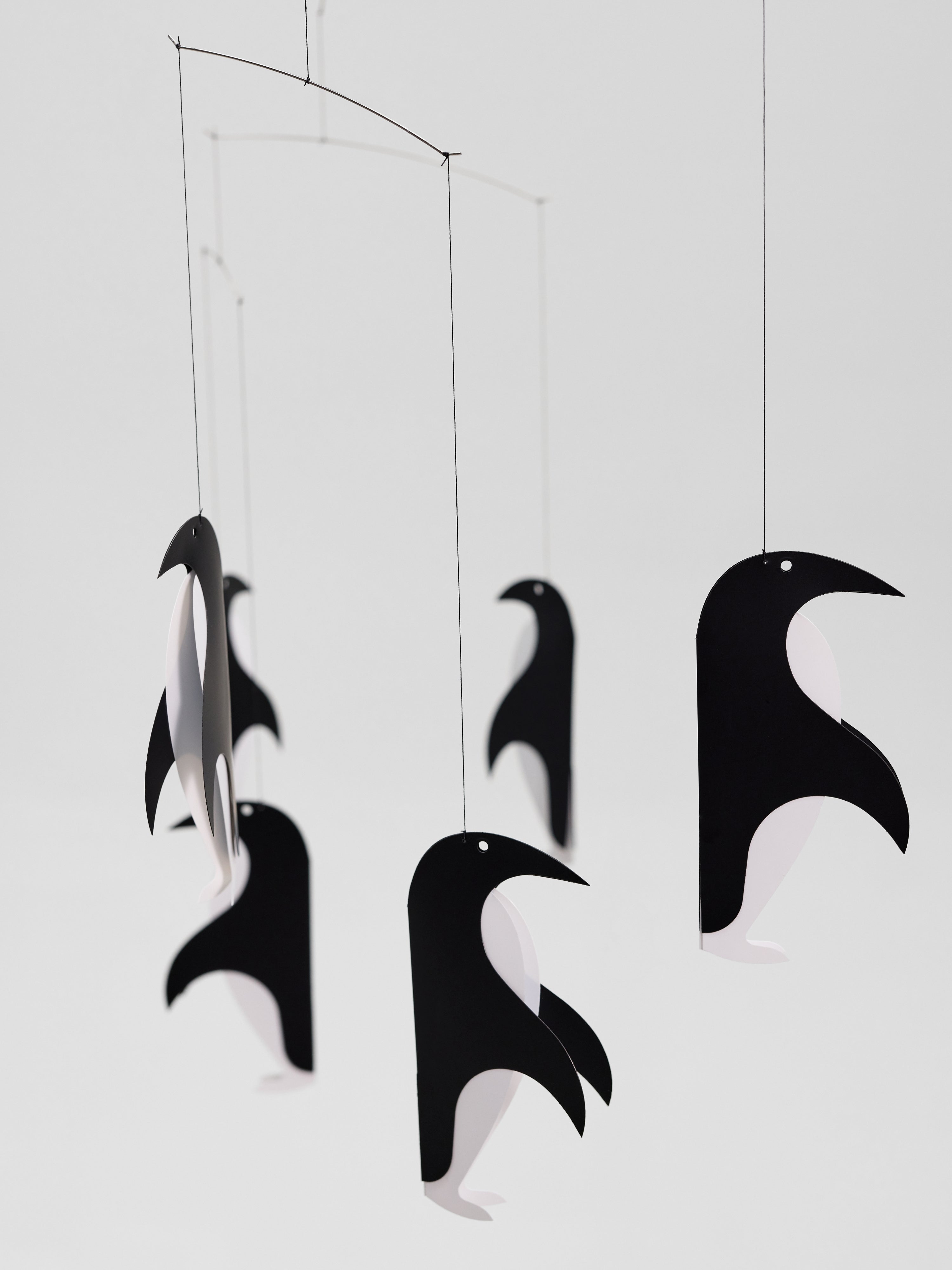 Penguin Talk mobiles featuring paper penguins hang from strings against a plain white background.