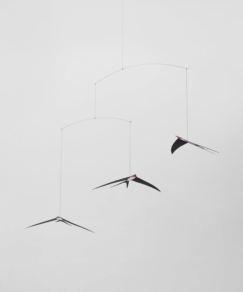 Le Mobile - Flying Swallows: A minimalistic black mobile featuring three abstract swallow shapes at varying heights against a plain white background.