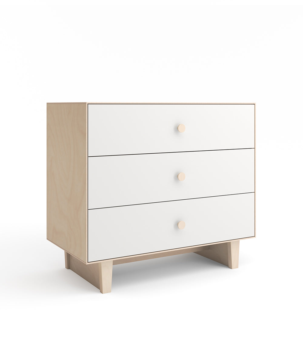 A wooden chest of drawers with three white drawers, each featuring a round knob, set on four rectangular legs against a white background.