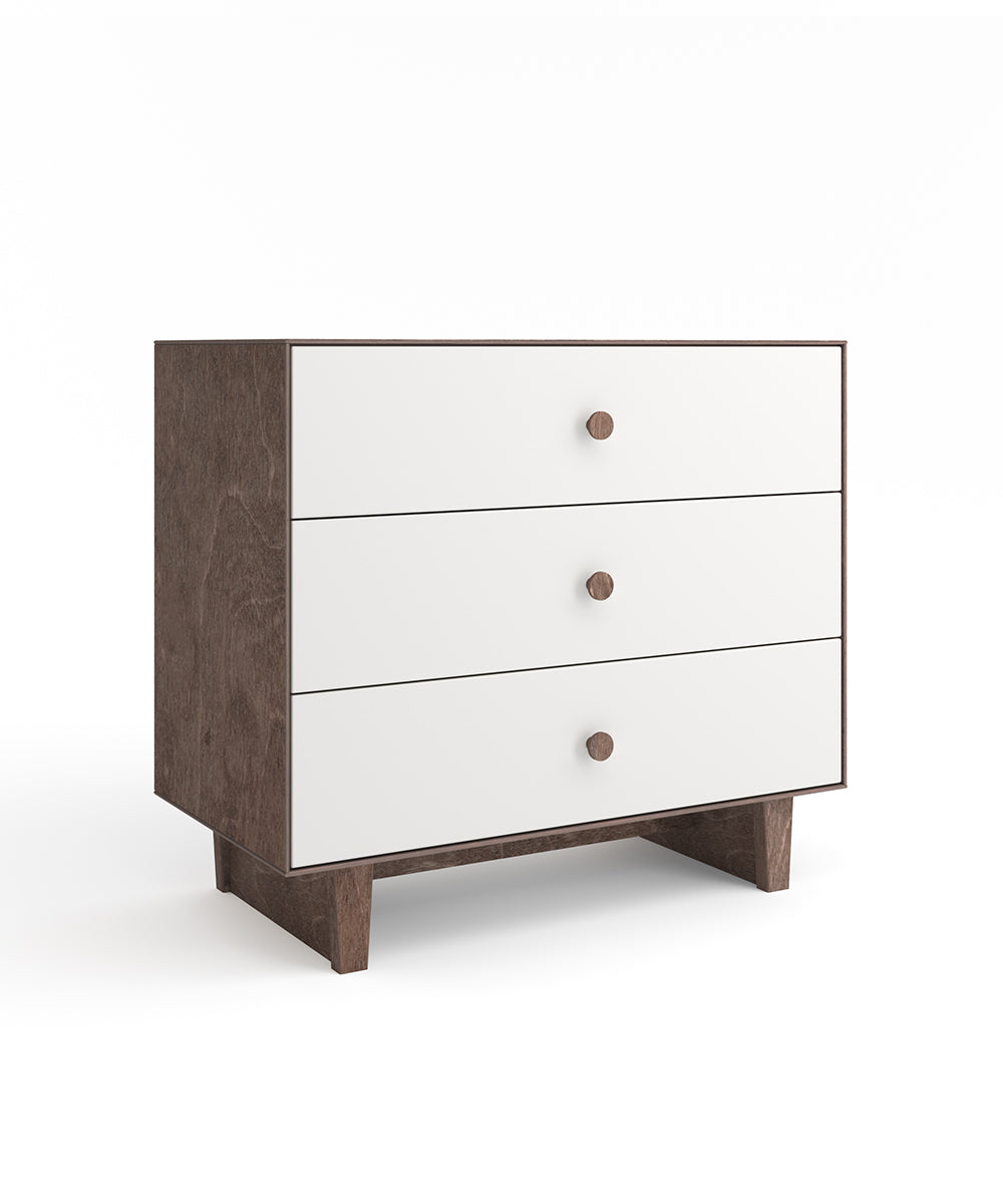 A wooden dresser with three white drawers and round knobs on short legs.