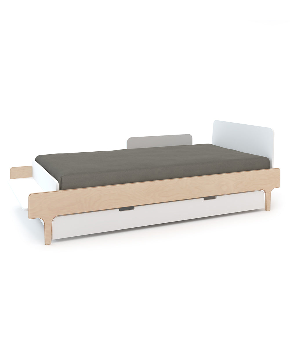 The Security Bed Rail attached to a modern single bed featuring a light wood frame and dark gray mattress.