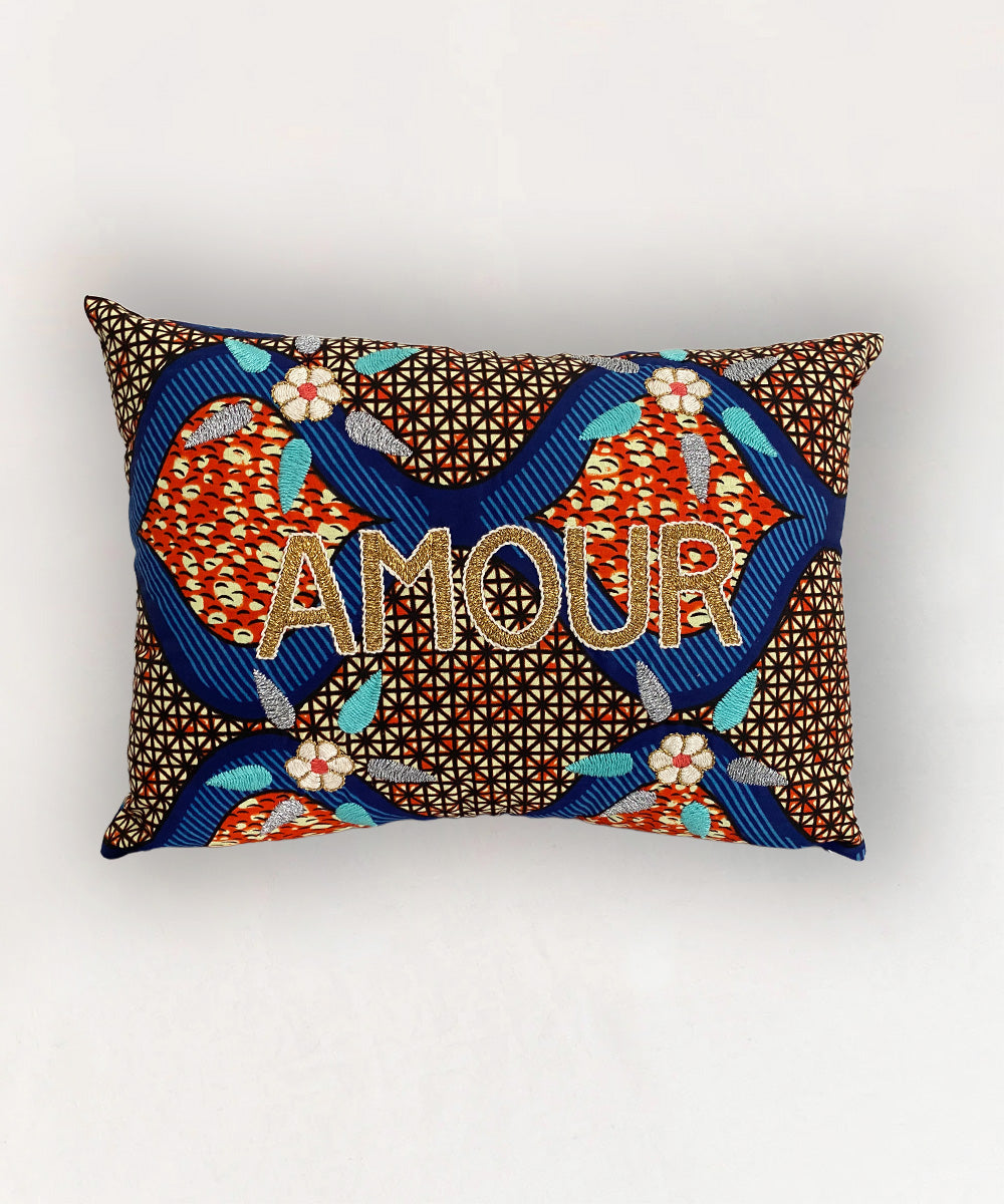 Le Embroidered Pillow - Sun Print Amour: Rectangular pillow featuring colorful geometric and floral patterns with "AMOUR" embroidered in gold.