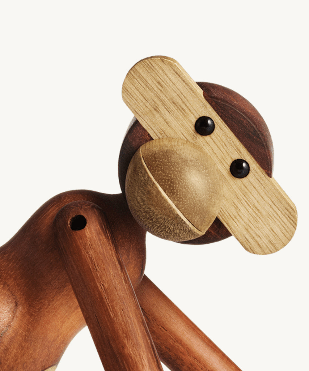 Le Monkey by Kay Bojesen: a wooden figurine with jointed limbs, round black eyes, and a wide, light wood snout.