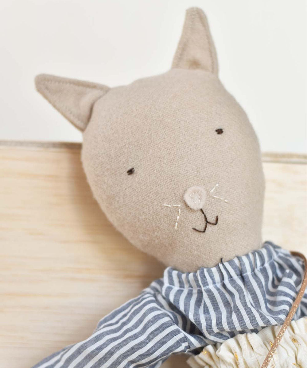 Mae le Cat stuffed animal doll wearing a field skirt, shown against a neutral background.