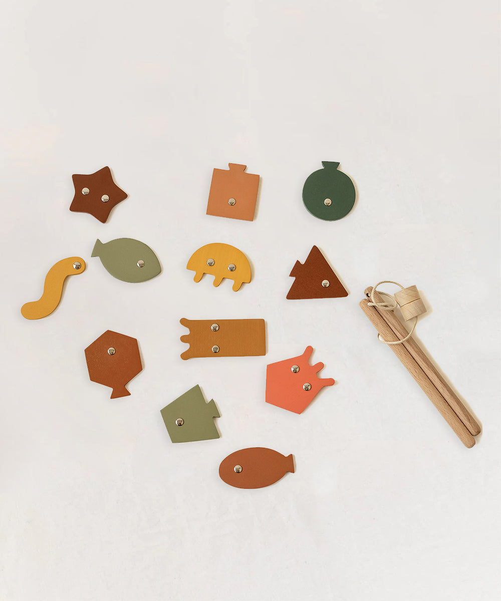 The Wooden Fishing Game includes colorful wooden animal and geometric shapes with eyelets and two stringed wooden sticks, shown on a white background.