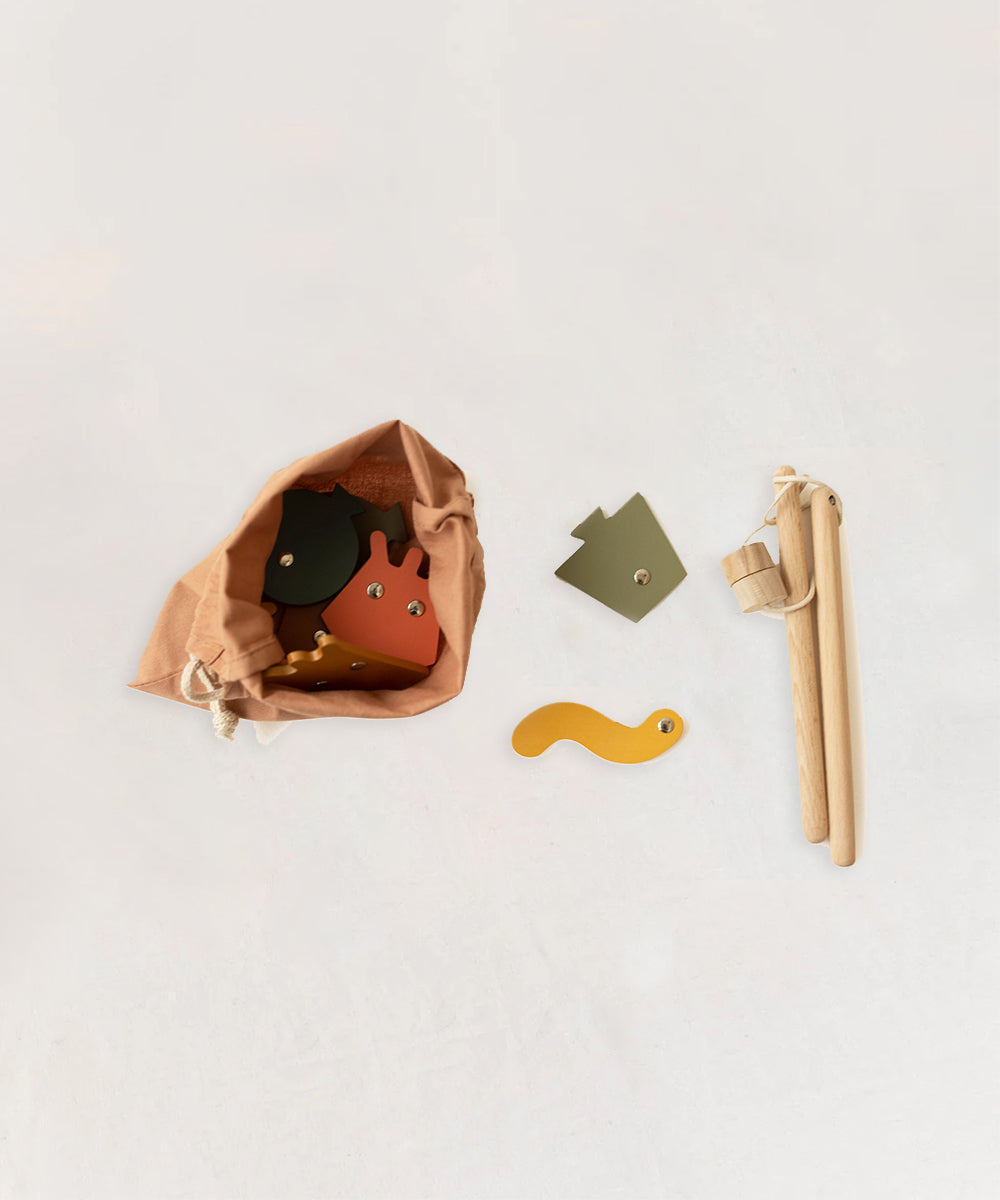 A Wooden Fishing Game featuring colorful shape pieces and wooden rods, all displayed on a light surface.