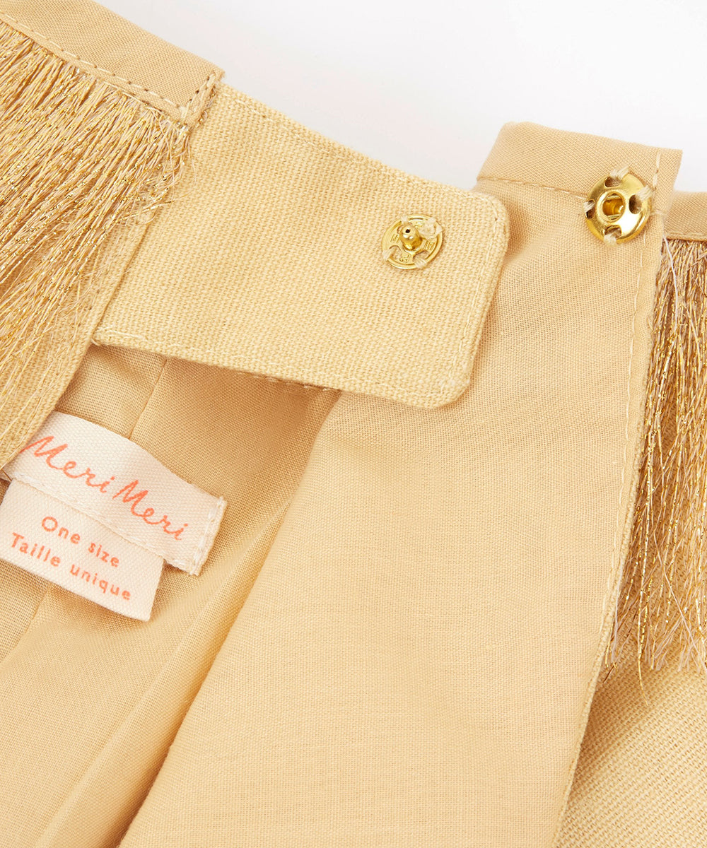 Close-up of the Lion Costume’s beige fabric with gold snap buttons, fringe detail, and a Meri Meri size tag.