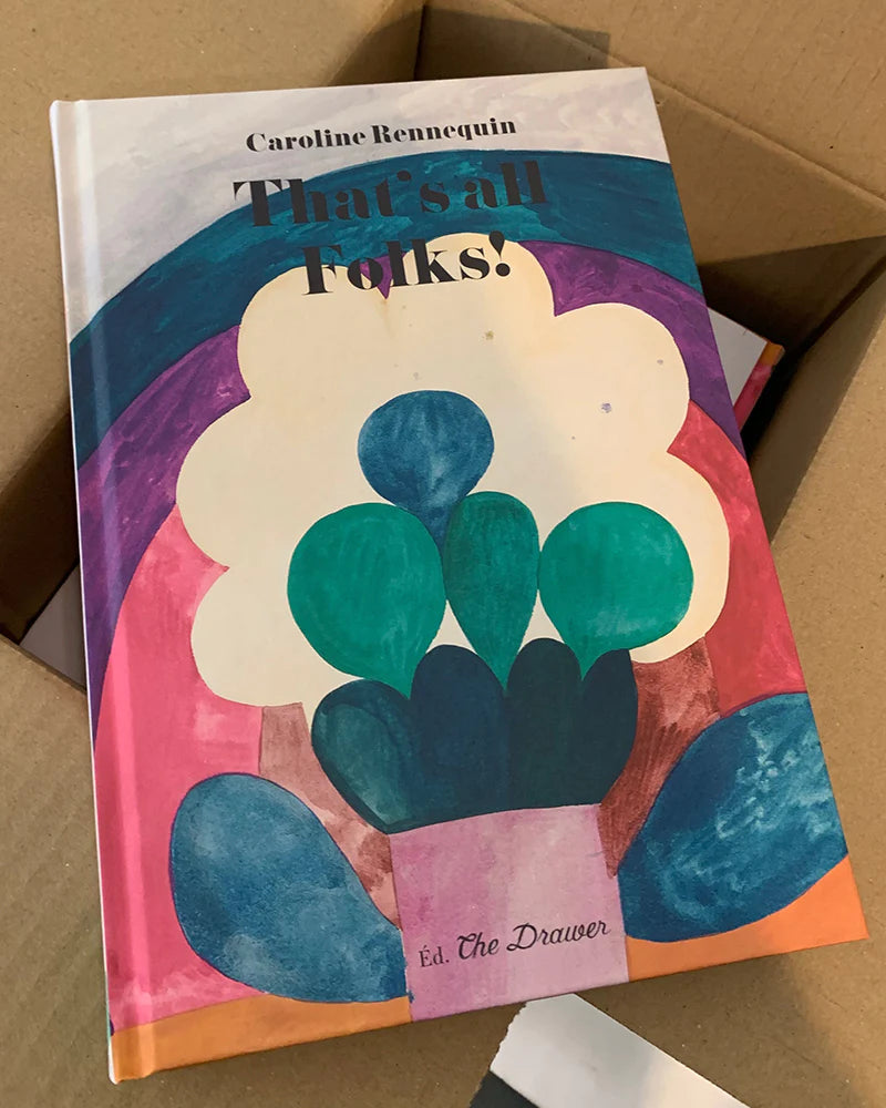 A book titled Thats all Folks! by Caroline Rennequin, featuring colorful abstract art on the cover, placed inside a cardboard box.
