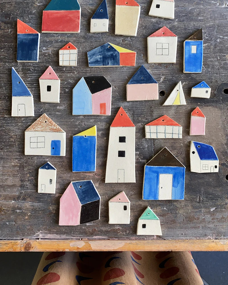 Colorful ceramic houses of various shapes and sizes arranged on a wooden surface.