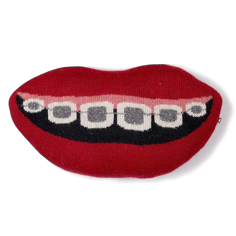 A red mouth-shaped pillow featuring a design of teeth with braces.