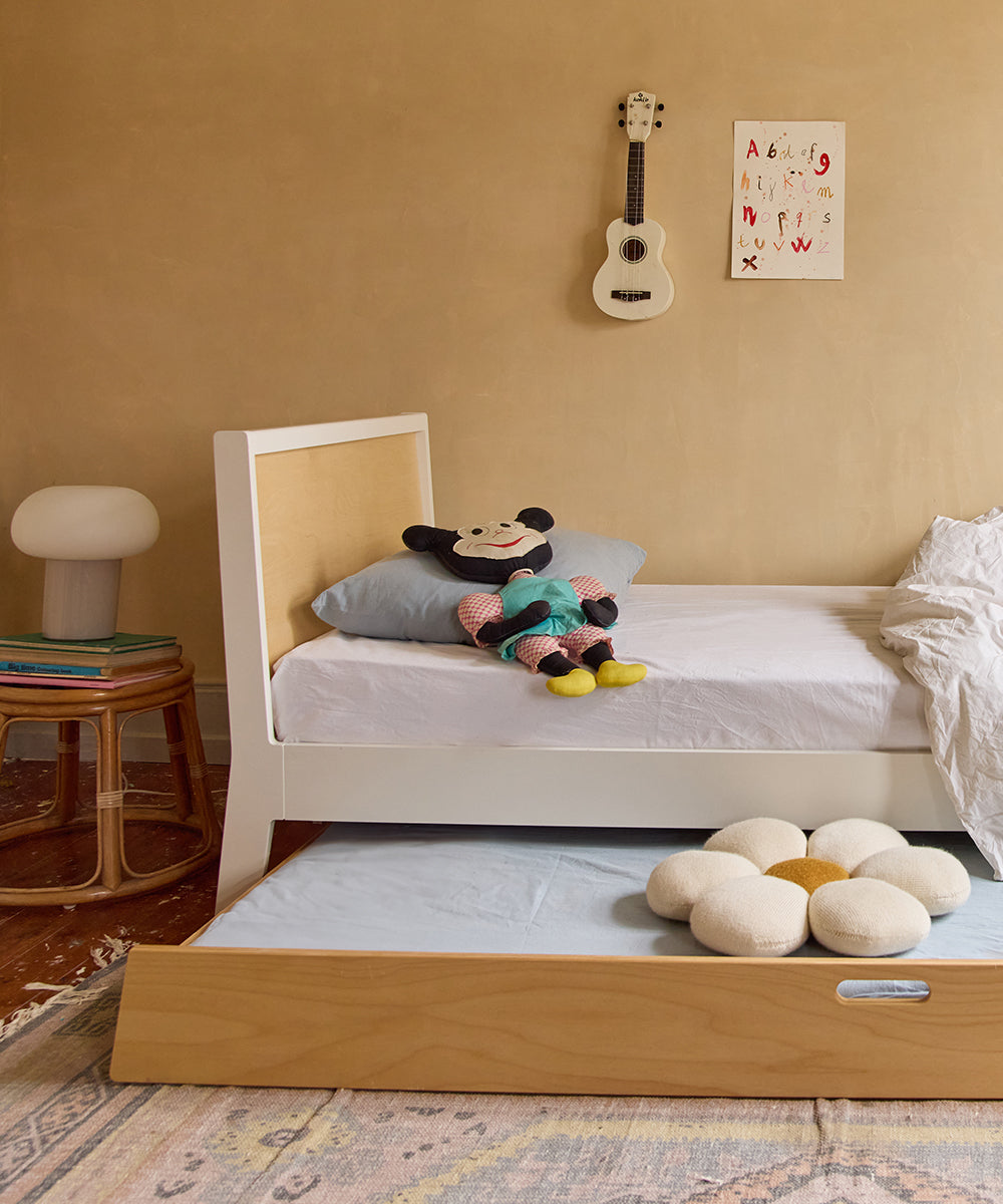 Cozy childrens bedroom featuring a Sparrow Twin Bed and Trundle Bed, plush toys, a guitar on the wall, and a decorative rug on the wooden floor.