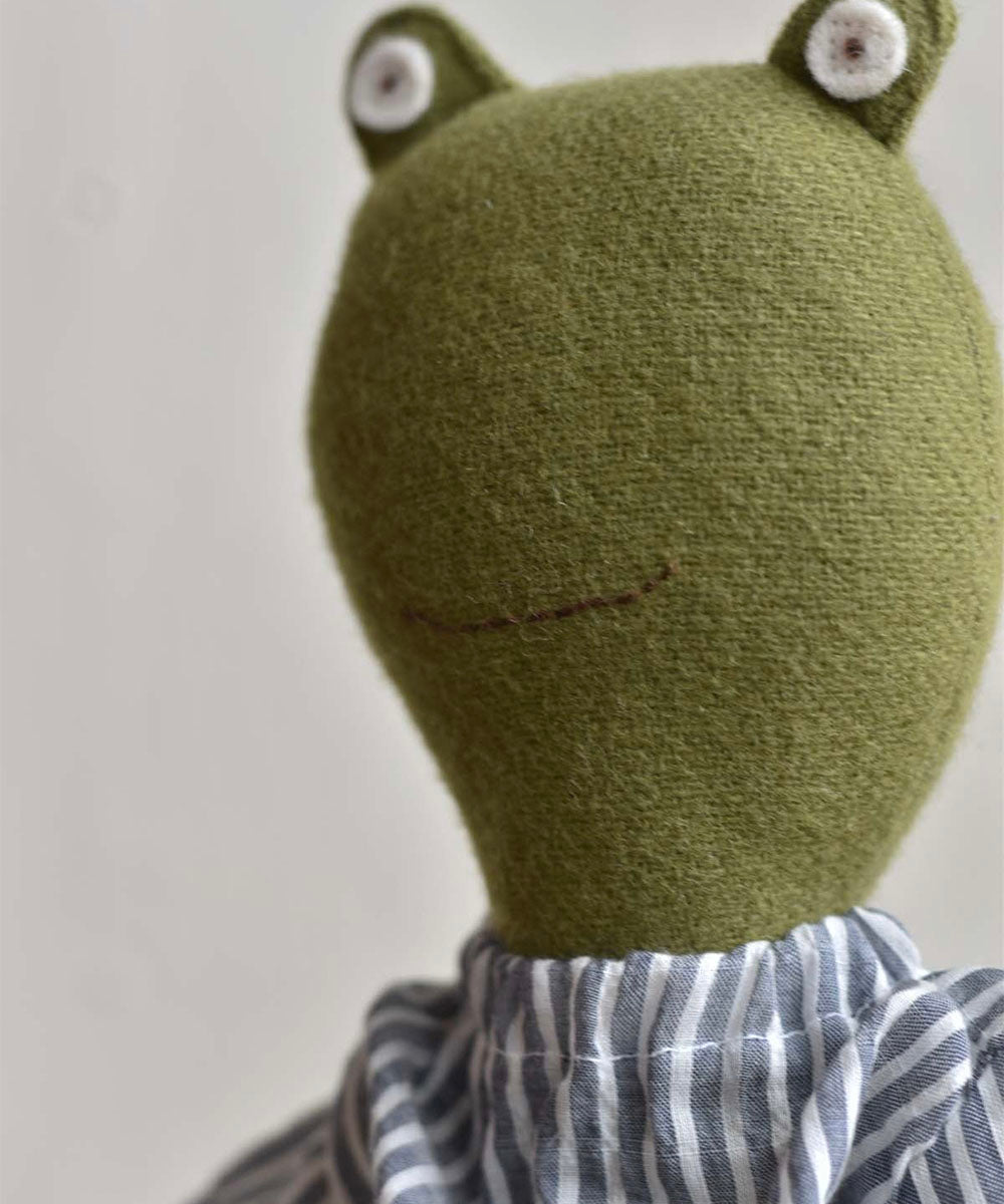 The Fern le Frog doll features button eyes, a sparkle skirt, and a soft design, shown against a plain background.