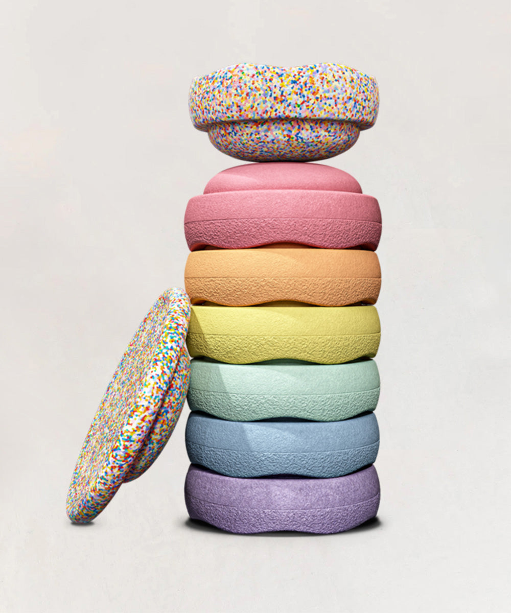 Le Stepping Stones - Complete Set: A stack of colorful, textured rings arranged in a rainbow gradient, topped with a sprinkled ring.