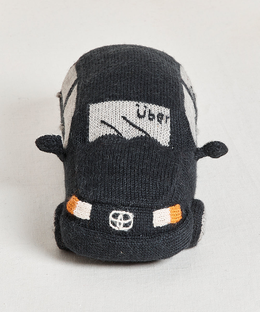 My Ride Pillow: Black knitted pillow shaped like a car, features "Uber" and wave symbol on windshield, visible front headlights, and logo.