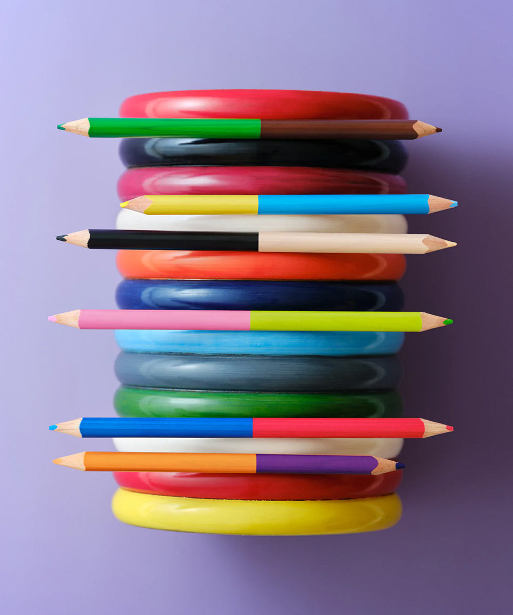 Le Dream Colored Pencils arranged horizontally with stacked colored rings, all on a purple background.