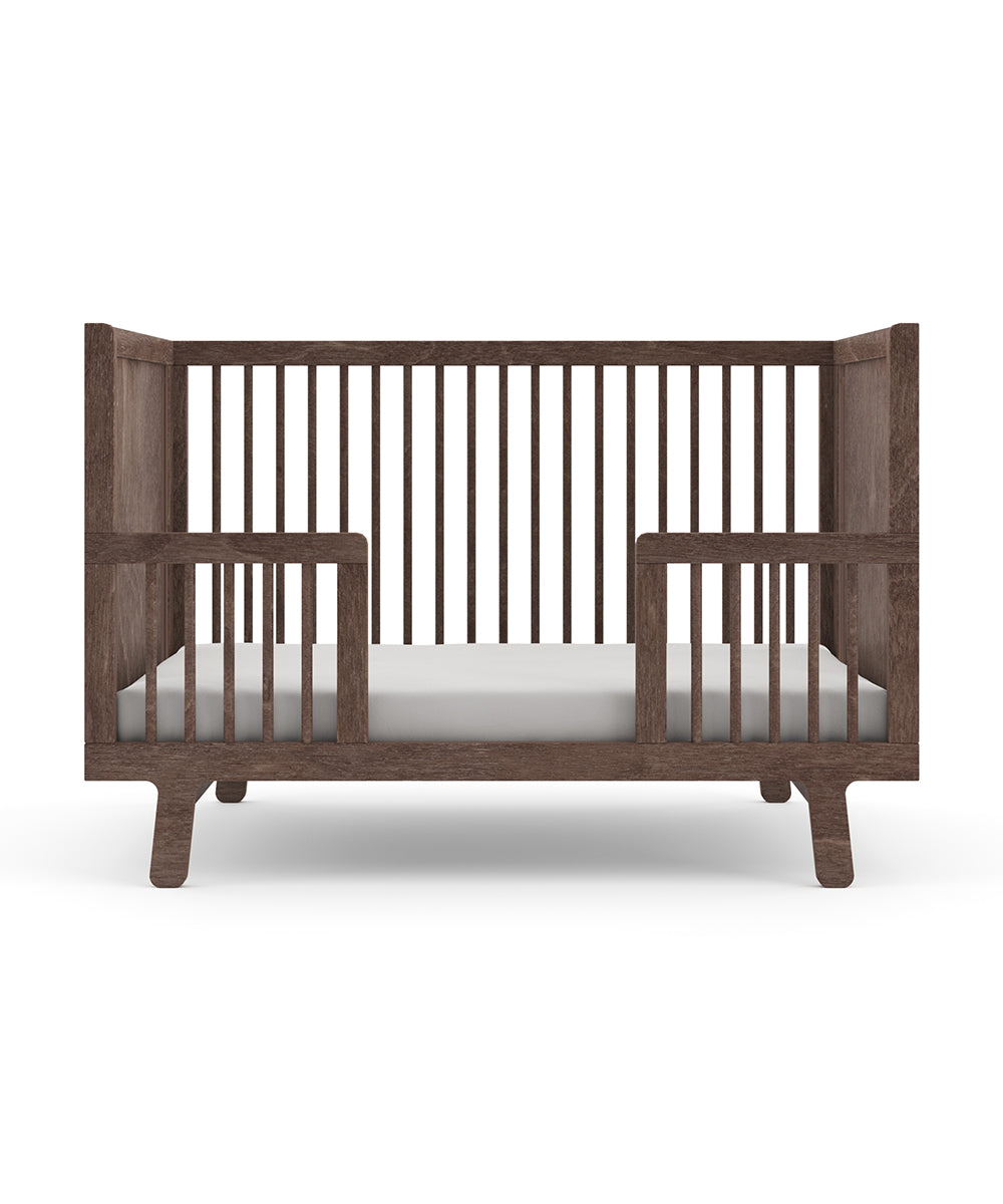 The Sparrow Toddler Bed Conversion Kit transforms your wooden crib with slatted sides into a modern, minimalist bed.