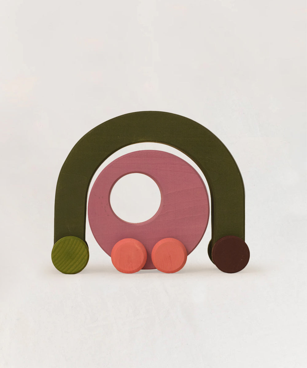 Le Vehicle Duet is a wooden toy car featuring green, pink, and red pieces arranged on a white background.
