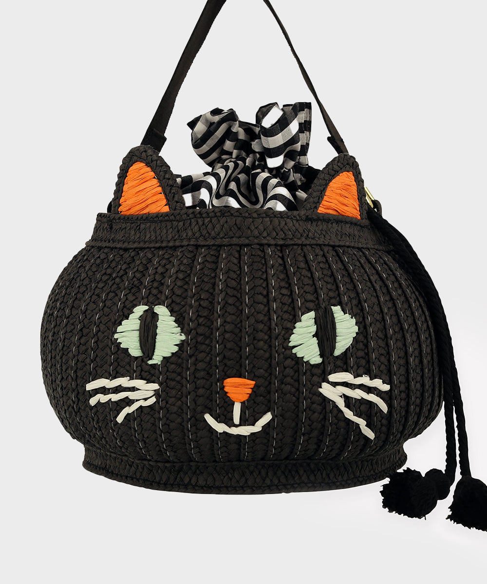 The Le Cat Basket Bag is a black woven bag with a cat face, orange ears, and black-and-white striped lining.