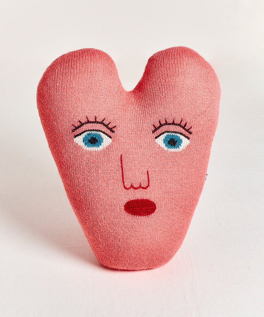 Heart Pillow: Pink, heart-shaped cushion with a surprised face, blue eyes, and red lips embroidered on the front.