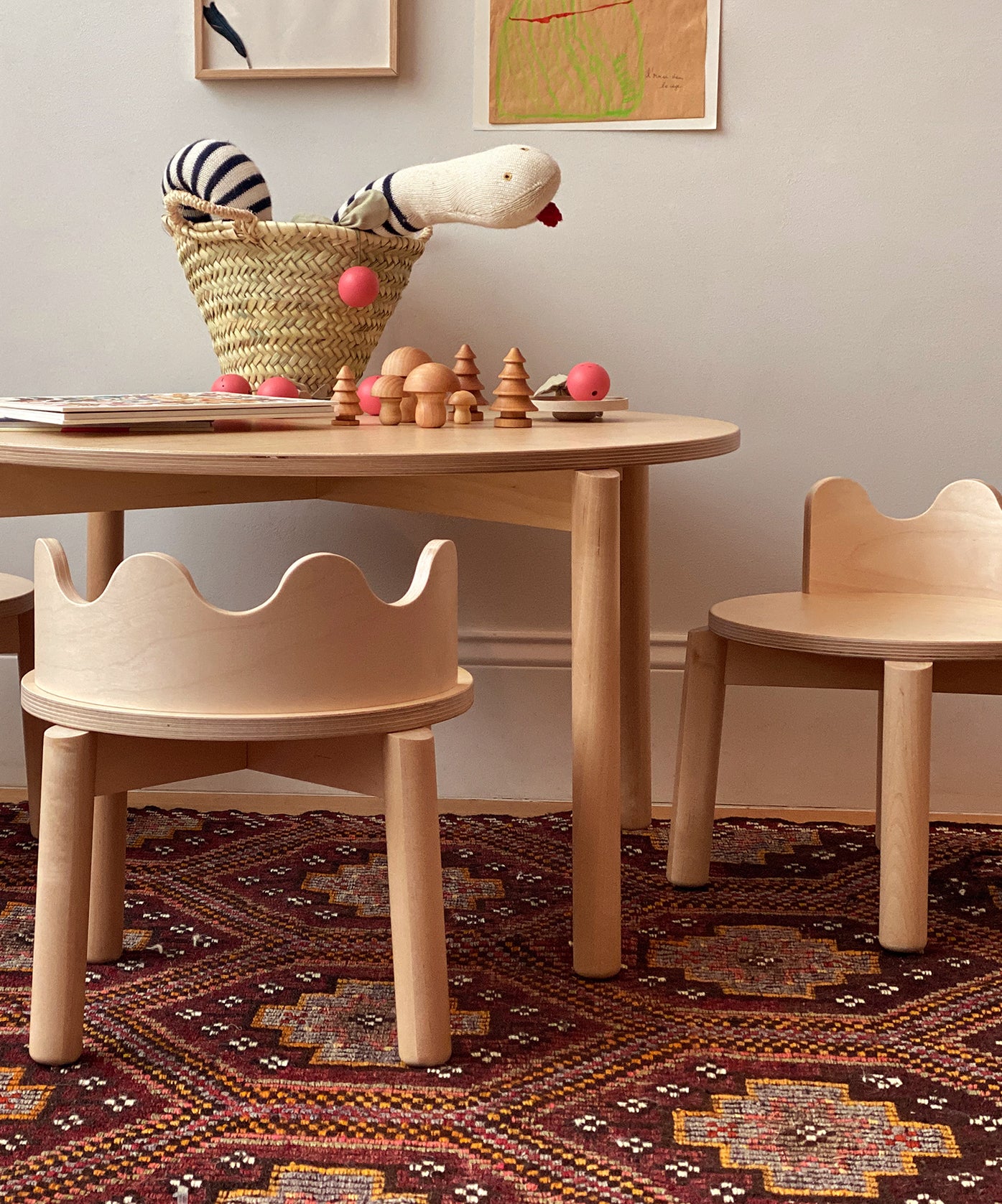 Moss Chairs with children's wooden table, toys, basket, and wall art on a patterned rug.