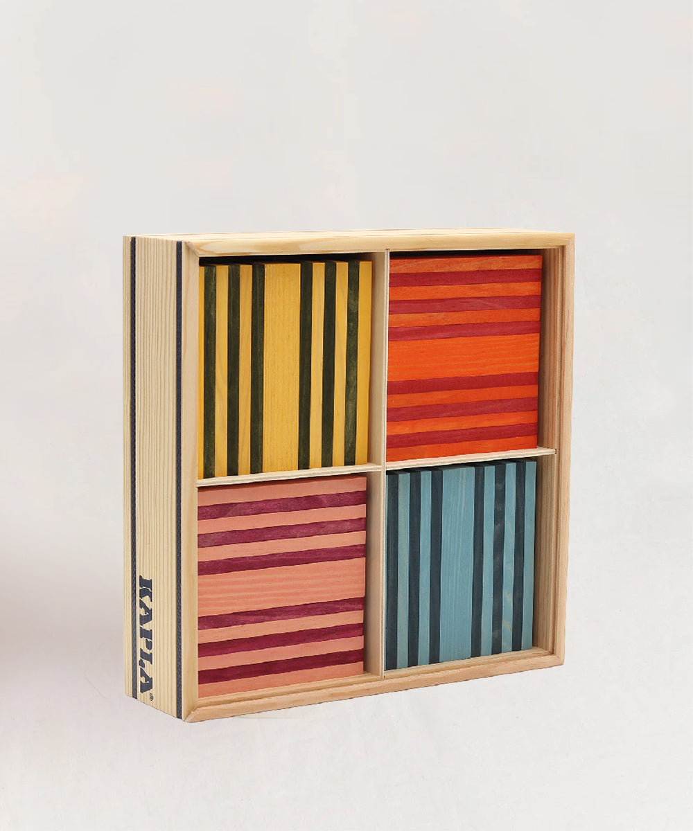 The KAPLA 100 Octocolor Case is a wooden box containing four sections of colorful striped blocks in yellow, red, pink, and blue.