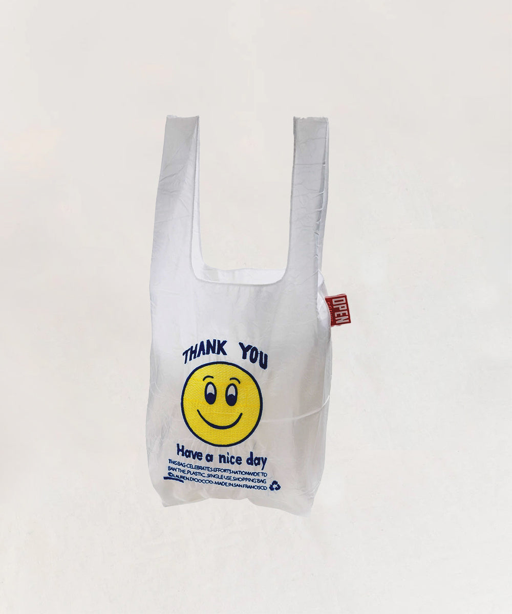 The Le Thank You Tote - Mini is a white reusable bag featuring a yellow smiley face and “Thank you, Have a nice day” text.