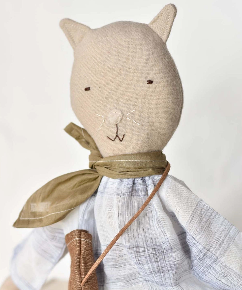 Mae le Cat is a stuffed fabric cat doll dressed in a scarf, plaid shirt, and a small crossbody bag.