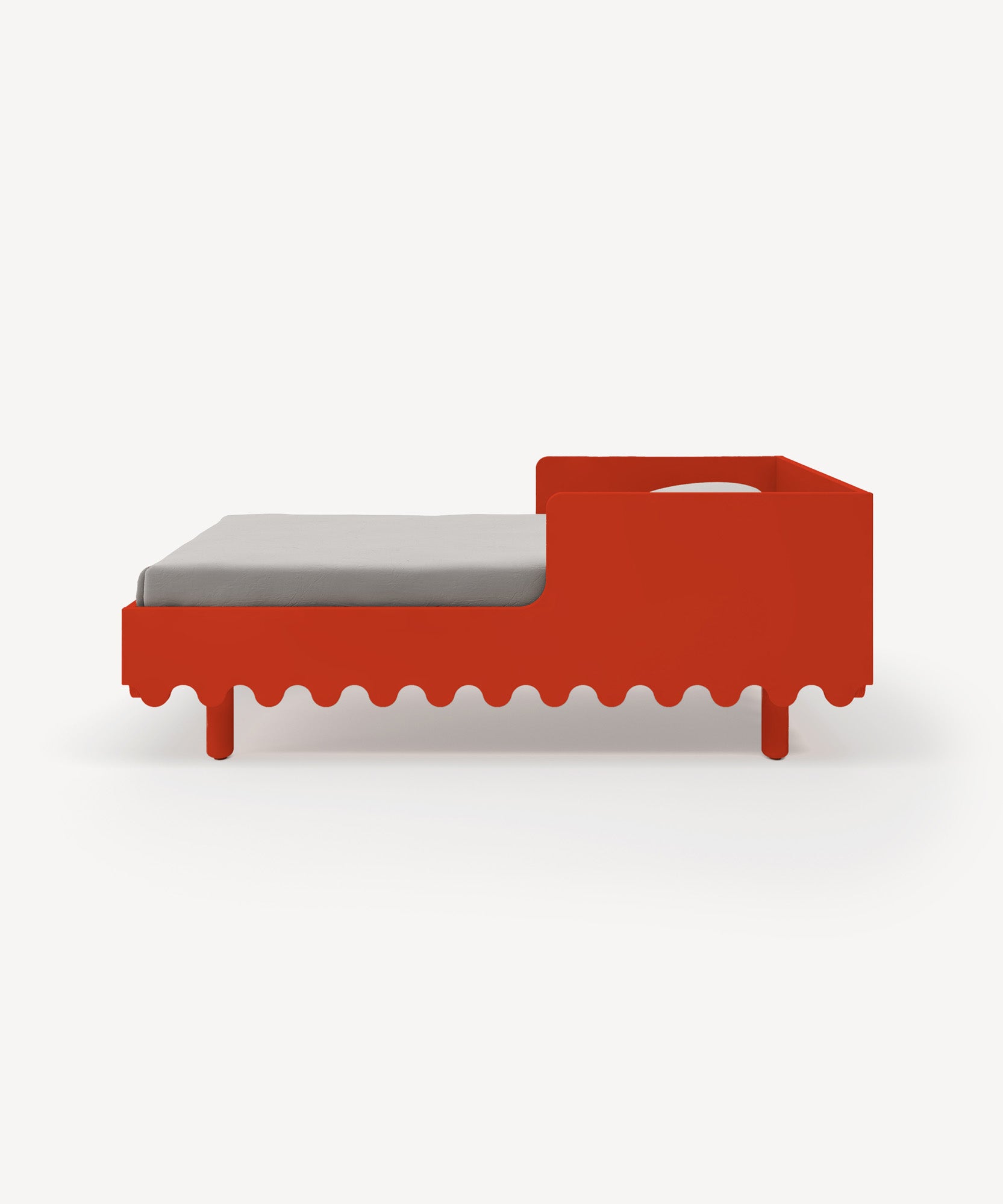 Moss Toddler Bed in red with a wavy edge, paired with a gray mattress on a plain white background.