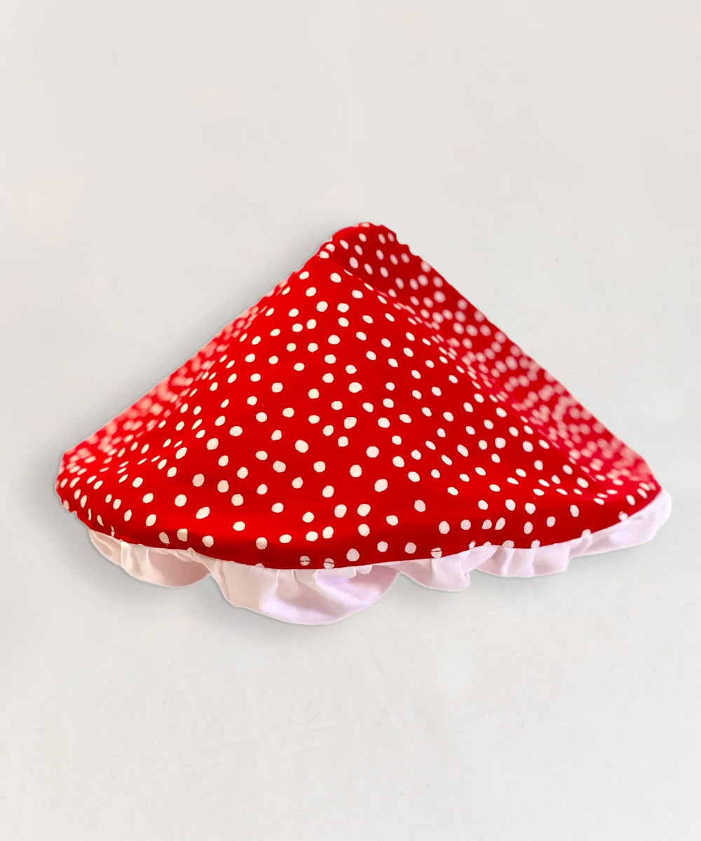 The Le Mushroom Hat features a triangular shape with red and white polka dots and a scalloped edge.