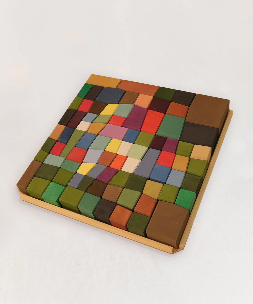 Le Oddy Cubes is a wooden tray set featuring colorful rectangular and square blocks arranged in a vibrant mosaic pattern.