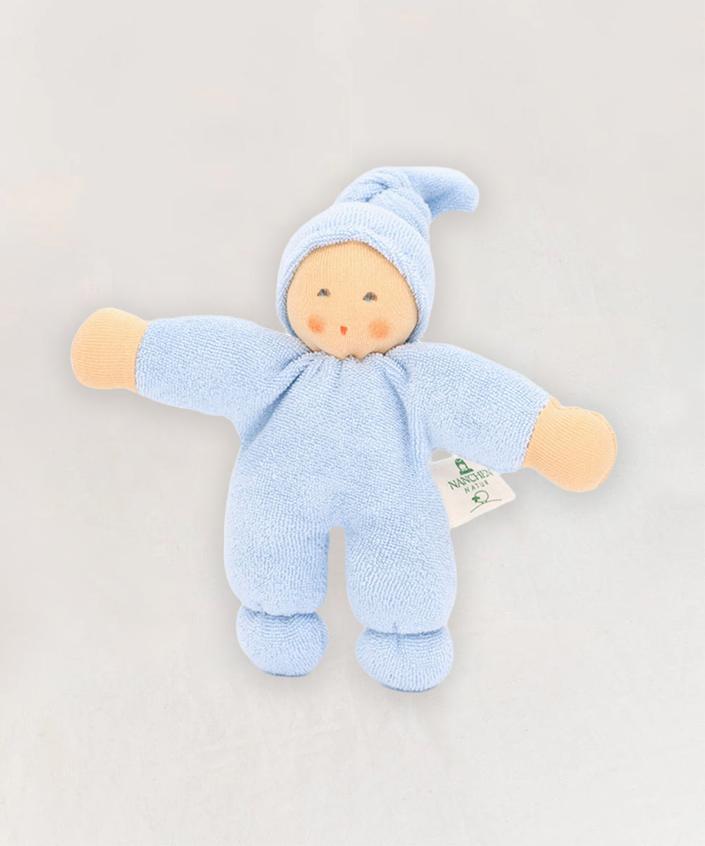 The Waldorf Doll - Blue is a soft doll in a blue onesie and hat, with a simple embroidered face, shown lying on a light background.
