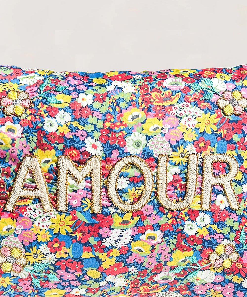 Le Embroidered Pillow - Amour features colorful florals and "AMOUR" embroidered in bold, textured letters.