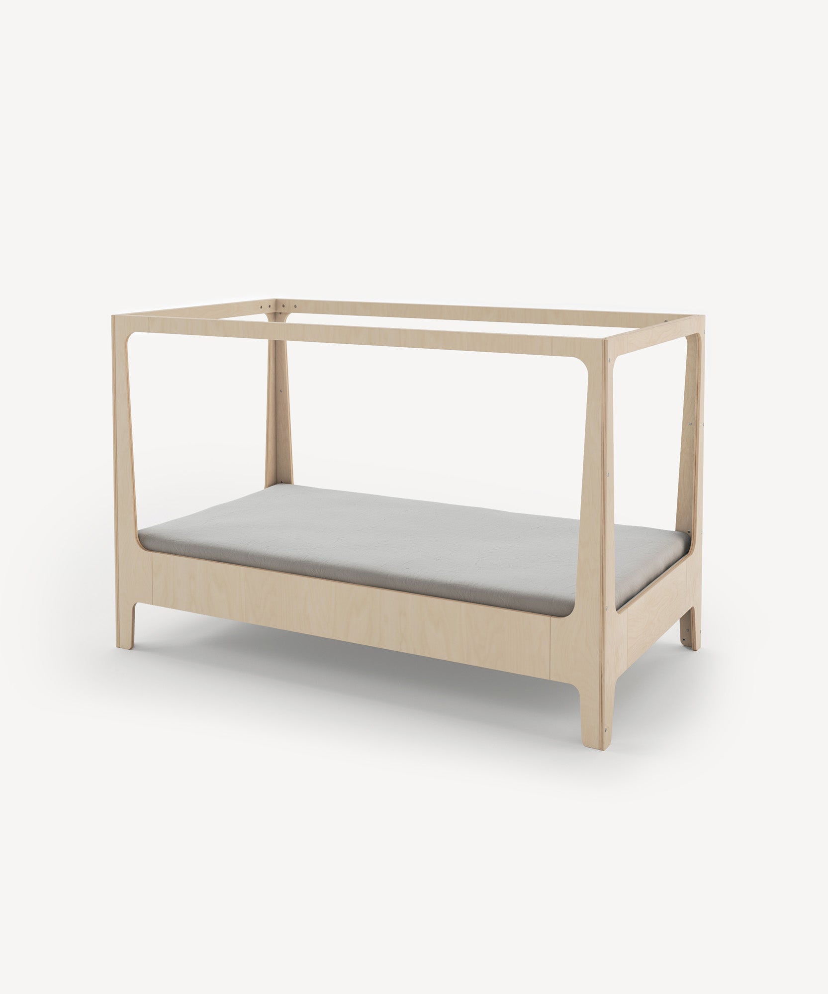 The Perch Nest Bed is a minimalist wooden crib with a light grey mattress, open sides, and a simple modern design.