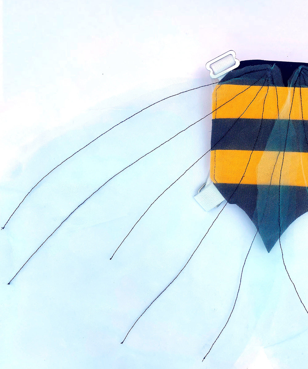 Bumble Bee Costume Wings with yellow and black stripes, six string legs, and a white tag, shown against a pale blue sky.