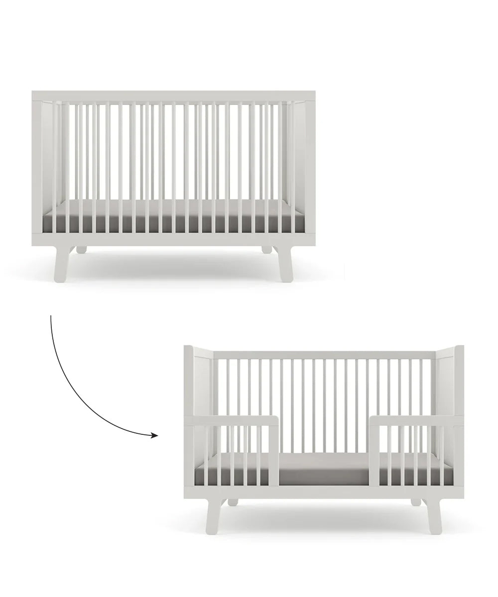 The Sparrow Toddler Bed Conversion Kit, made from sustainable materials, seamlessly transforms the full crib into a toddler bed with an open side.