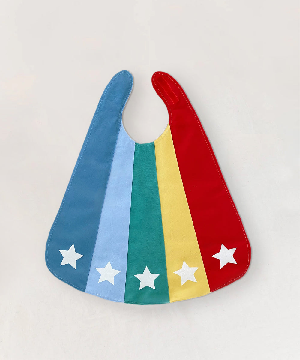 Le Superhero Cape features vertical stripes in blue, green, yellow, and red, each adorned with a white star near the bottom.