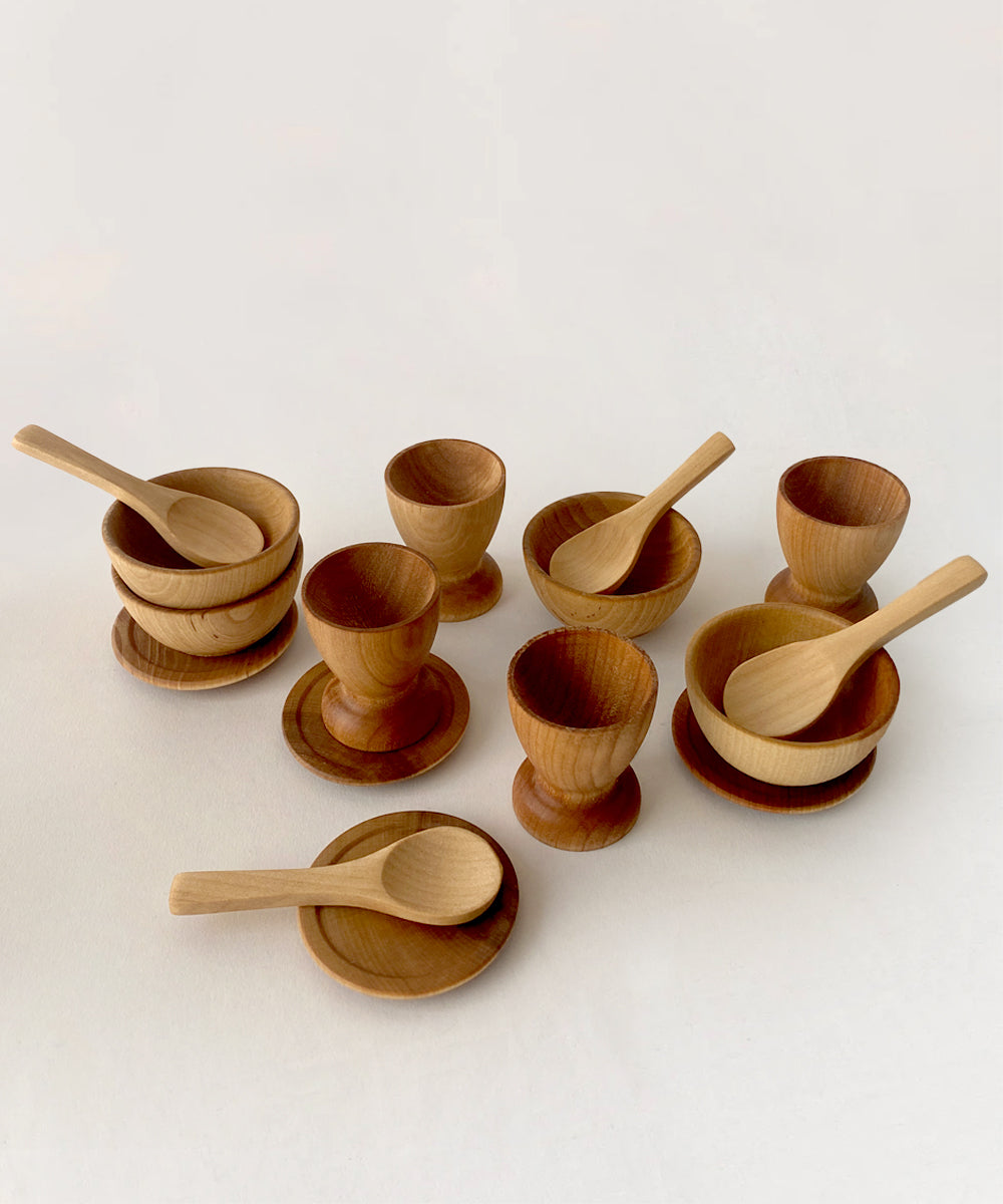 Le Wooden Dish Set, featuring bowls, plates, and spoons, neatly displayed on a light surface.