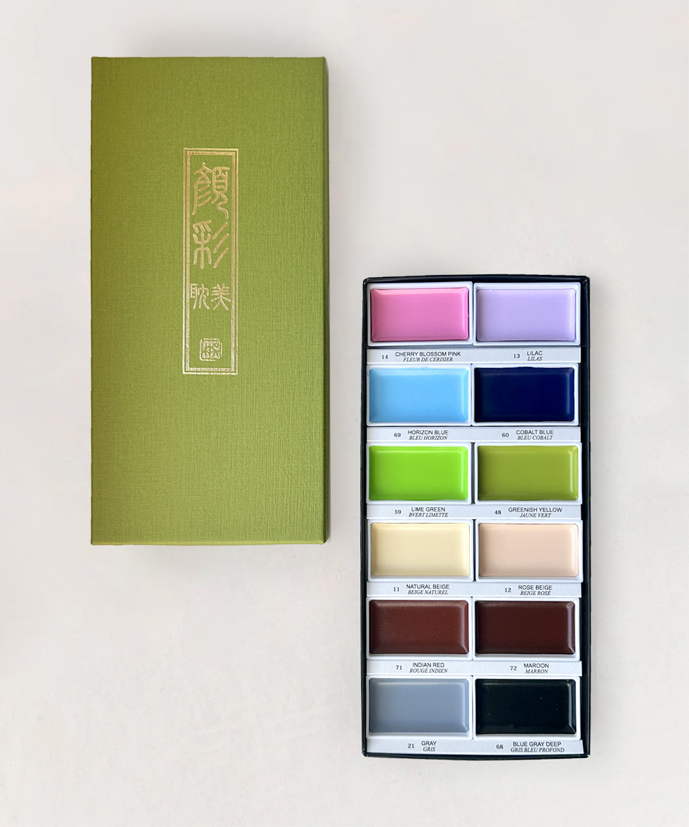 An open Gansai Tambi Watercolor Paint Set - Pastel Colors with twelve shades beside a green lid with gold text.