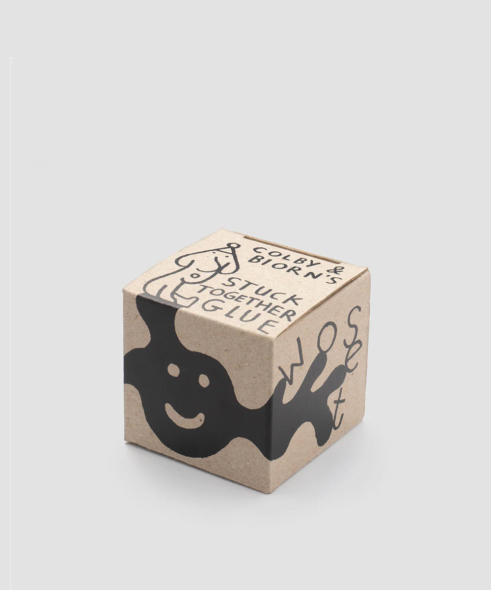 A brown, cube-shaped box with playful black graphics and "Le Gentle Scissors" text.