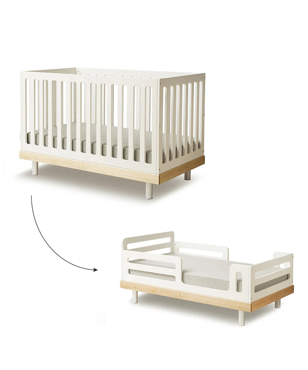 The Classic/Arbor Toddler Bed Conversion Kit is a white convertible crib featuring slatted sides and crafted from sustainable materials. It easily transitions between crib and toddler bed, promoting big-kid independence with an included conversion kit.