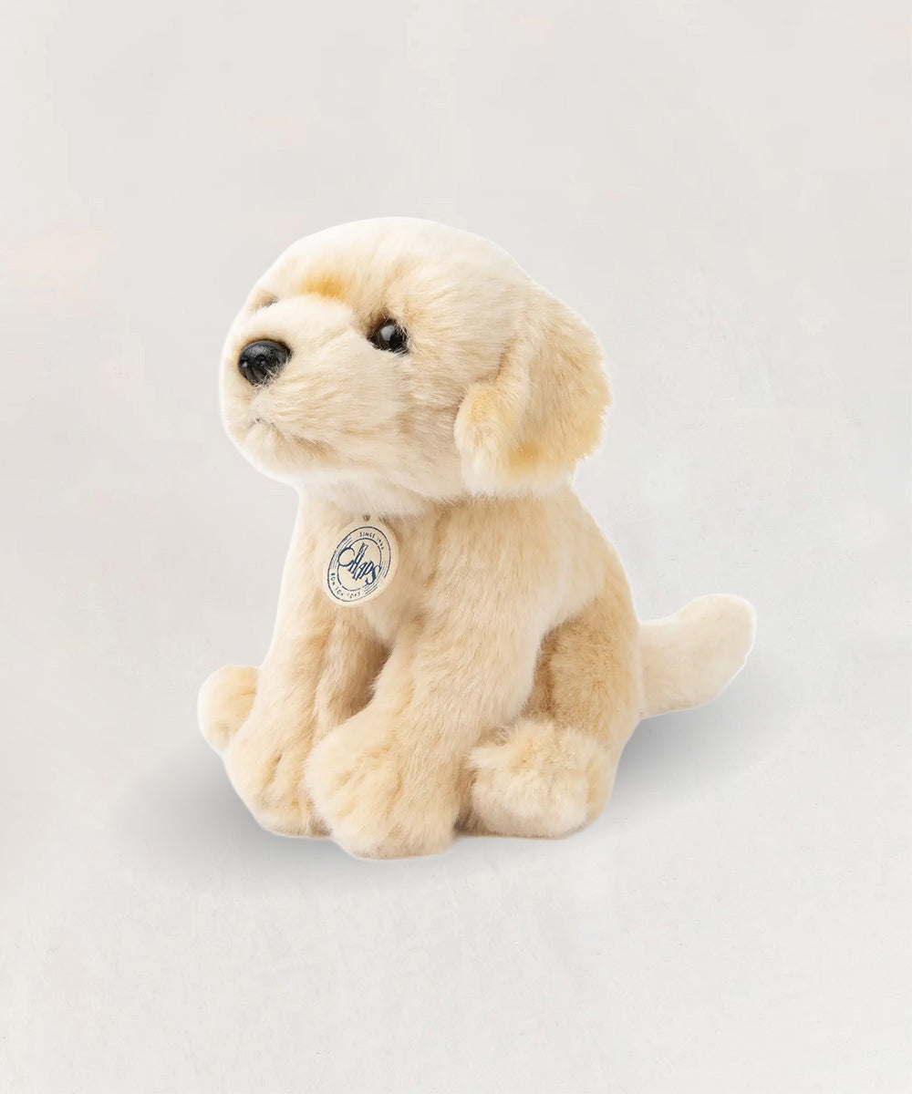 Loulou le Labrador is a beige plush puppy toy with a tag, shown sitting on a plain light background.