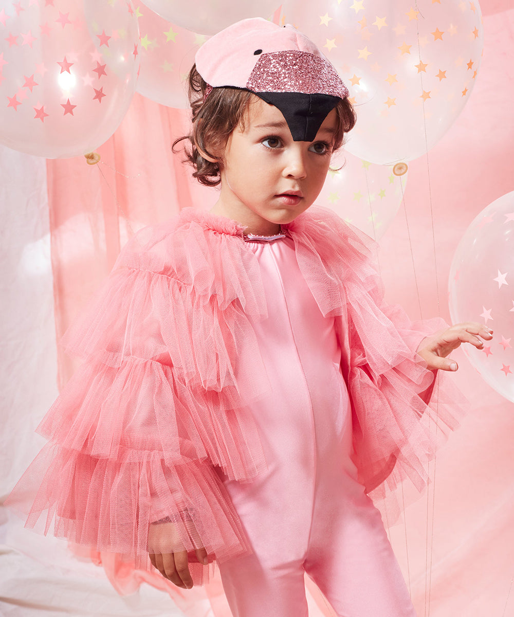 A child wears a Flamingo Costume featuring ruffled sleeves, standing among balloons decorated with star patterns.