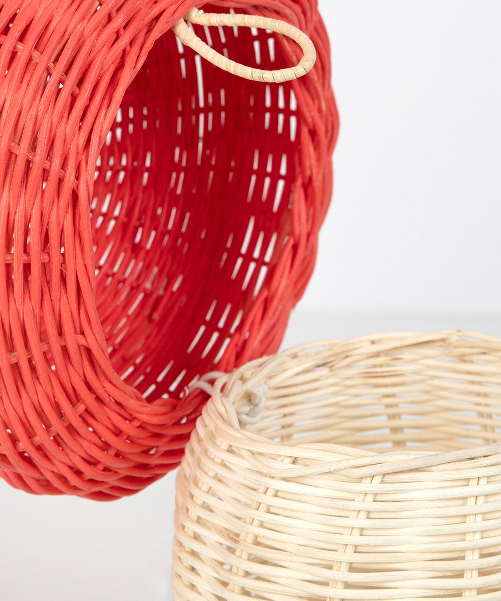 Two Mushroom Baskets, one red and one light beige, are overlapping each other against a plain background.