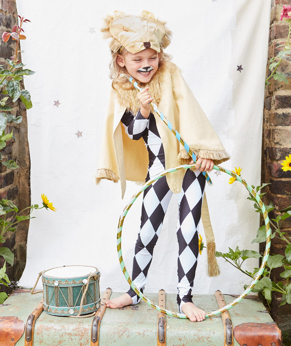 A cheerful child wearing the Lion Costume holds a hula hoop, standing beside a toy drum and sunflowers.